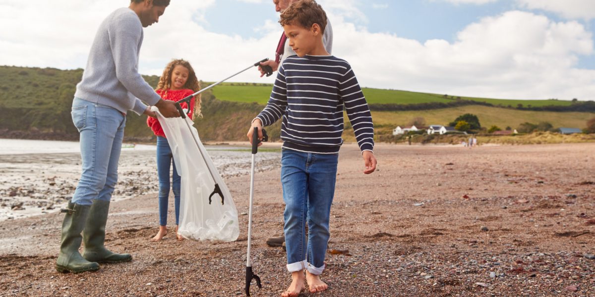 Multi-Generation Family Collecting Litter On Winter Beach Clean Up