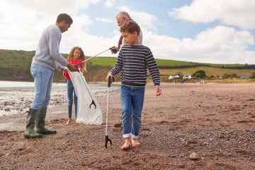 Multi-Generation Family Collecting Litter On Winter Beach Clean Up