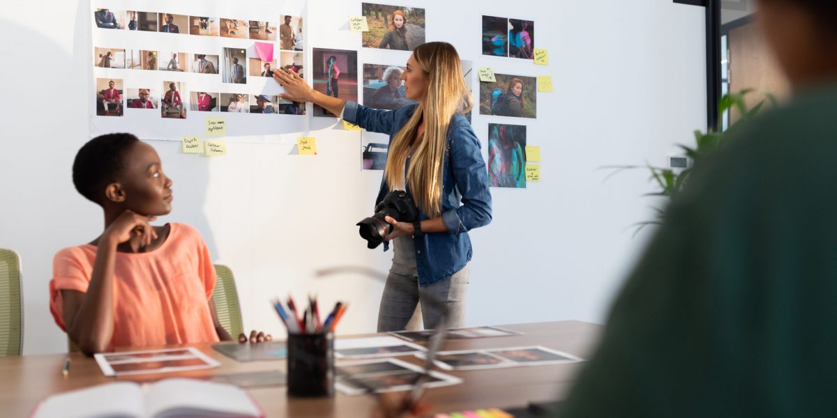 Diverse group of business colleagues brainstorming looking at photos in meeting room. independent creative business in modern office.