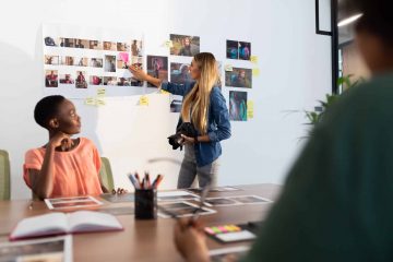 Diverse group of business colleagues brainstorming looking at photos in meeting room. independent creative business in modern office.