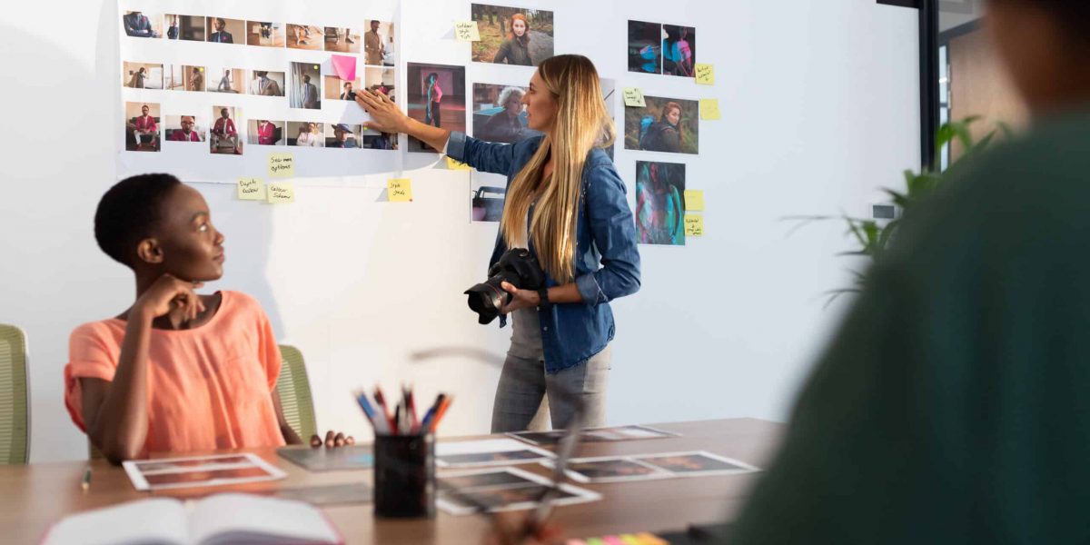 Diverse group of business colleagues brainstorming looking at photos in meeting room. independent creative business in modern office.