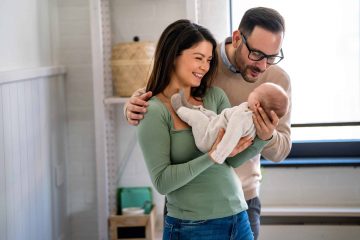 Family, adoption, baby, parenthood and people concept. Happy mother, father with newborn baby at home