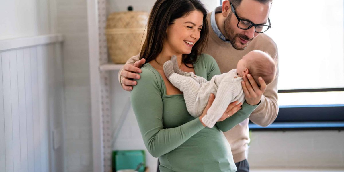Family, adoption, baby, parenthood and people concept. Happy mother, father with newborn baby at home