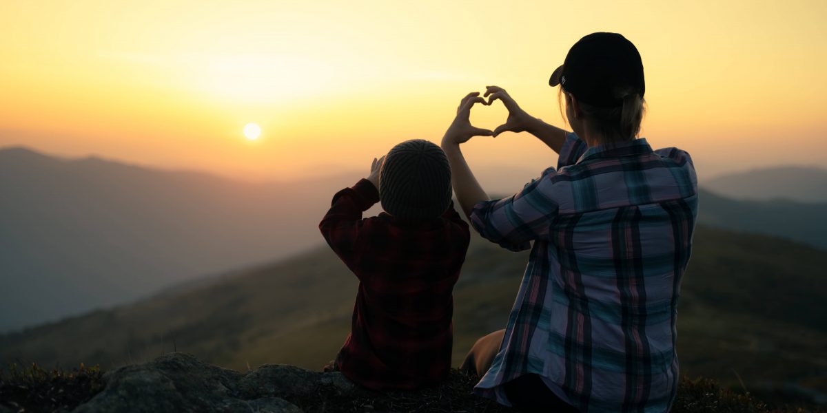 Mom with son in the autumn mountains during sunset. Travel with child concept