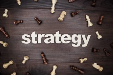 word strategy and chessmen on the brown wooden background